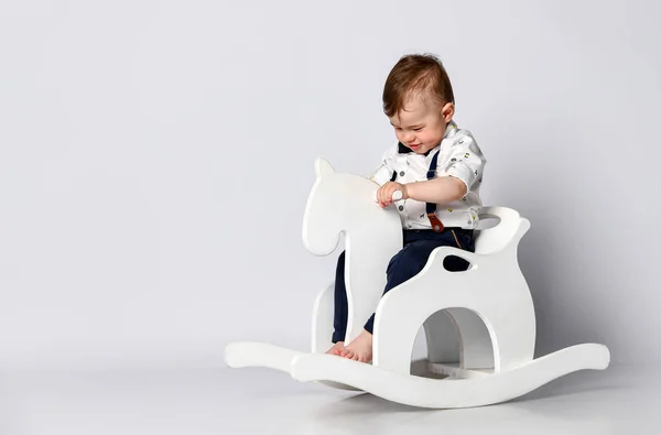 Funny baby sitting on the toy horse — Stock Photo, Image