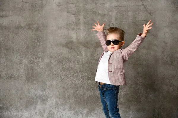Зображення веселого збудженого маленького хлопчика, який стоїть ізольовано над бетонною стіною . — стокове фото