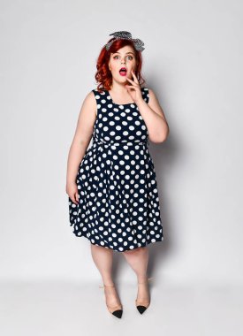 Kızıl saçlı kadın portresini sabitle. Kırmızı dudaklar ve manikür çivi ve eski moda saç modeli ile polka nokta elbise güzel retro kadın