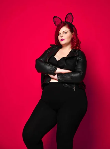 Kırmızı arka planda poz deri ceket ve iç çamaşırı siyah Bunny kulakları ile sevimli seksi artı boyutu esmer