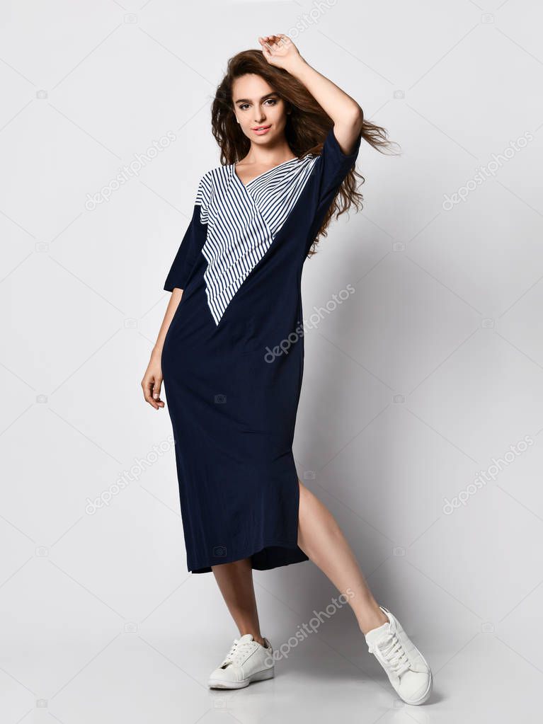 Fashionable woman in a beautiful long blue dress with a light insert, sneakers. Fashion spring summer autumn photo