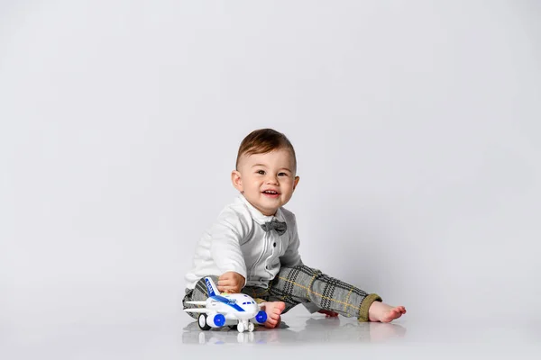 Happy child toddler playing with toy airplane and dreaming of becoming a pilot — Stock Photo, Image