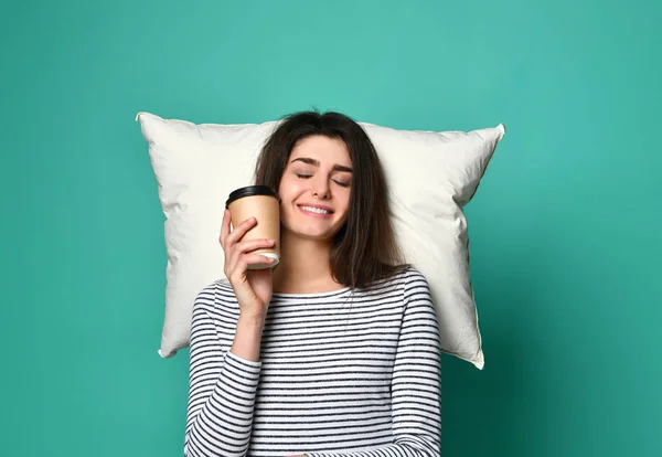 Счастливая молодая женщина с чашкой кофе или чая в руках, мечтает на подушке о чем угодно — стоковое фото