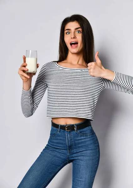 Lycklig ung kvinna som håller ett glas med mjölk — Stockfoto