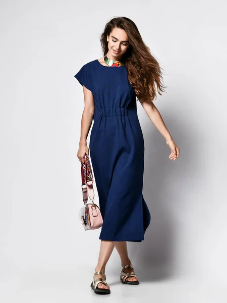 Modelo femenino rizado delgado en un vestido urbano azul en pleno crecimiento. Una chica encantadora con ropa romántica va a una cita, a la oficina, a una reunión. Moda urbana —  Fotos de Stock