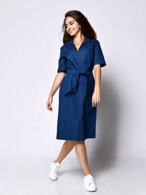 Tam büyüme mavi bir kentsel elbise ince kıvırcık kadın modeli. Romantik kıyafetler giyen güzel kız randevuya gider, ofise, toplantıya. Kentsel moda