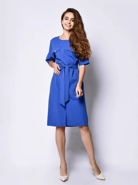 Slender curly female model in a blue urban dress in full growth. Lovely girl in romantic clothes goes on a date, to the office, to a meeting. Urban fashion — Stock Photo, Image