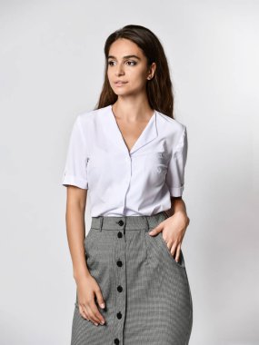 güzel kadın ofis yöneticisi yeni bir rahat beyaz bluz ve klasik düz koyu etek poz