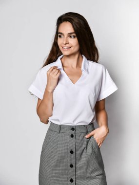 güzel kadın ofis yöneticisi yeni bir rahat beyaz bluz ve klasik düz koyu etek poz