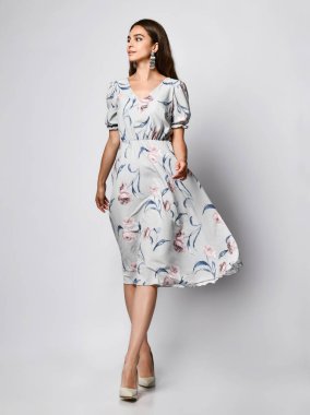 Uzunluğu gül desenli narin uçan elbisesiyle muhteşem bir kız.