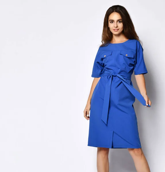 Modelo feminino encaracolado esbelto em um vestido urbano azul em pleno crescimento. A menina encantadora na roupa romântica vai a uma data, ao escritório, a uma reunião. Moda urbana — Fotografia de Stock