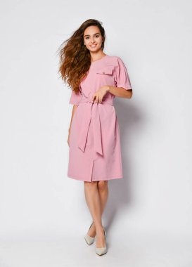 Tam uzunlukta portre Studio beyaz arka plan üzerinde izole poz pembe içinde mutlu güzel kadın