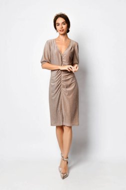 Pudra pembesi elbiseli, genç ve güzel görünümlü güzel bir bayan. Beyaz üzerine izole edilmiş tam boy portre