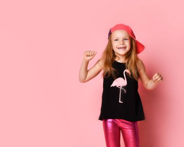 Pembe arka planda izole edilmiş müzik dinlerken dans eden ve eğlenen mutlu kız arkadaşlarının tam boy portresi.