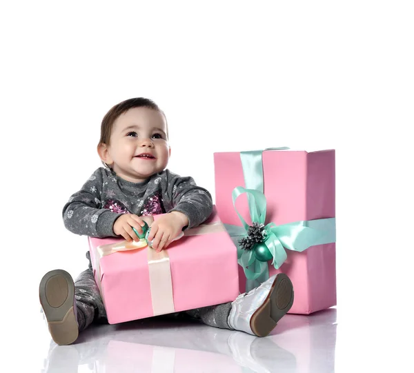 Criança de fato cinzento e botas. Ela sorrindo, segurando rosa decorado caixa de presente, sentado no chão isolado em branco. Fechar — Fotografia de Stock