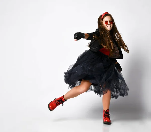 Joven modelo positivo de chica de talla grande en ropa de estilo rock brillante, botas rojas y accesorios de pie y bailando —  Fotos de Stock