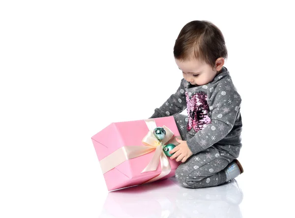 Портрет ребенка, открывающего подарочную коробку в белой студии — стоковое фото