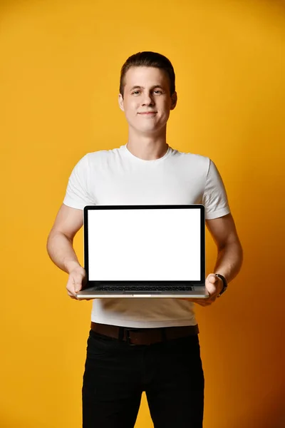 Elinde dizüstü bilgisayar tutan yakışıklı bir genç. — Stok fotoğraf