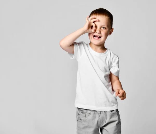 Ragazzo che guarda attraverso le mani, facendo binocoli Fotografia Stock