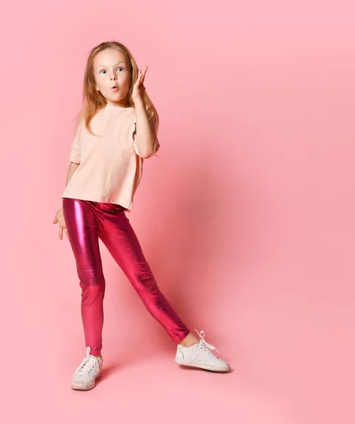 Porträt eines schockierten jungen Mädchens in rosa Leggings, das mit Mund in die Kamera blickt — Stockfoto