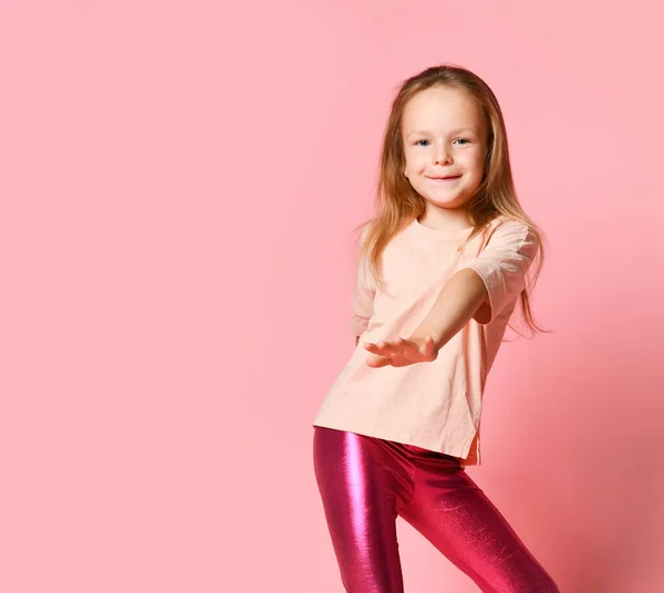 Retrato de uma menina feliz dançando e se divertindo enquanto ouve música, puxa a mão — Fotografia de Stock