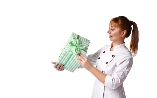 Dame in medisch uniform glimlachend, groene geschenkdoos vastgebonden met lint. Ze poseren geïsoleerd op wit. Verkoop, reclame. Sluiten. — Stockfoto