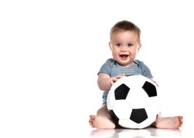 Küçük çocuk elinde bir futbol topu tutuyor ve beyaz bir arka plana hapşırıyor..