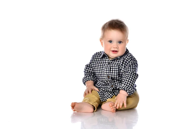 Funny baby boy assis pieds nus dans une chemise à carreaux et un pantalon. — Photo