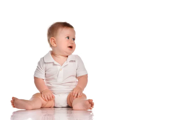 Intrigued baby in a white bodysuit looks to the side on a white background. — Stock Photo, Image