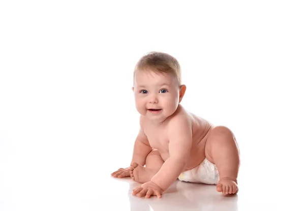 Söt småbarn i blöjor ler glatt på vit bakgrund — Stockfoto
