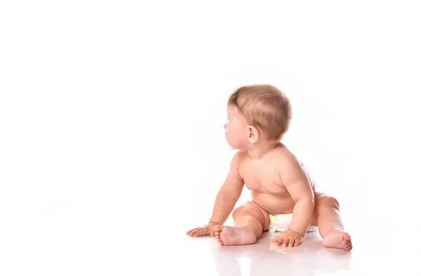 Cute baby w pieluchy patrząc z tyłu siedzi na podłodze — Zdjęcie stockowe