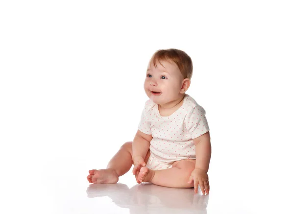 Söt överraskad liten flicka sitter på studio golv — Stockfoto