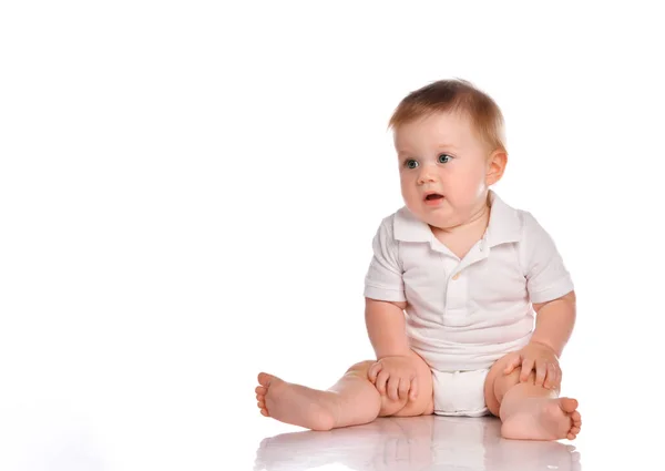 Cute little boy in white bodysuit sitting isolated on white — Stock Photo, Image