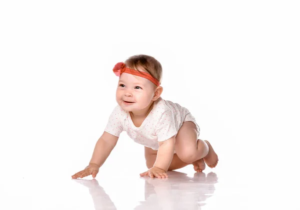 Sorrindo bebê menina rasteja de quatro em um fundo branco. — Fotografia de Stock