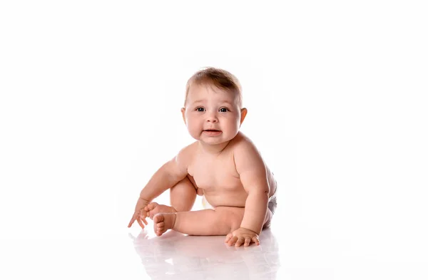 Ett år gammal naken flicka sitter på vit bakgrund. — Stockfoto