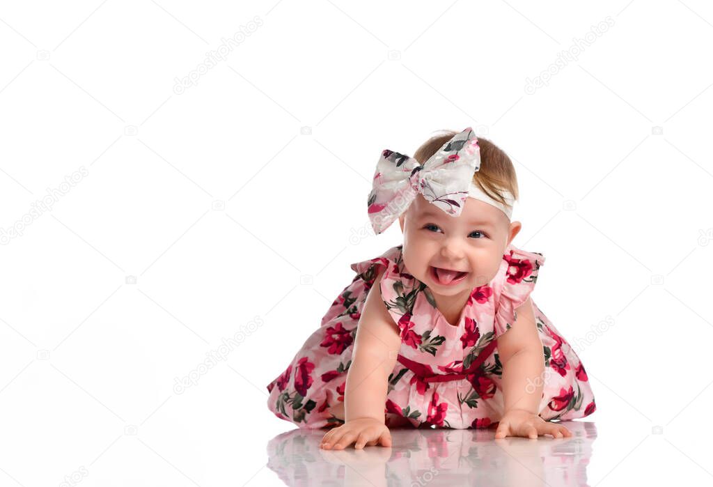 Happy little baby girl in dress crawling on floor