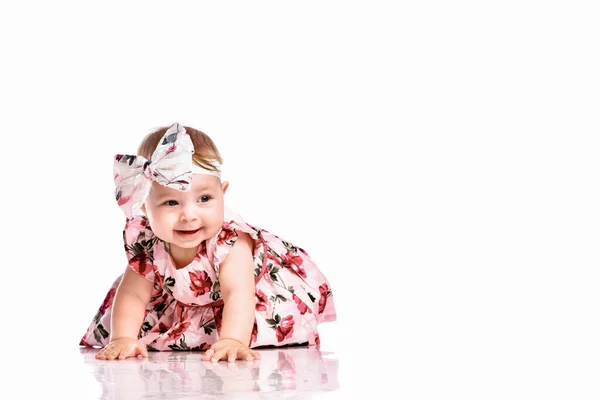 Bella bambina strisciando sul pavimento bianco dello studio — Foto Stock