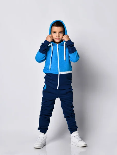 Modelo menino em traje de esportes decolando capuz — Fotografia de Stock