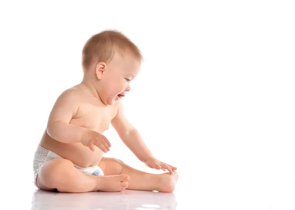 Adorável bebê sentado e olhando para o lado sobre fundo branco — Fotografia de Stock