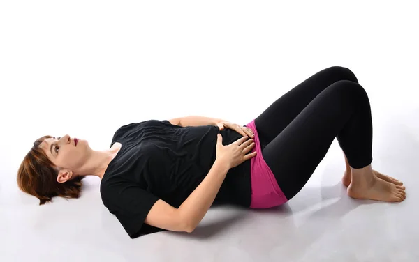 Beyaz arka planda nefes egzersizleri yapan bir kadın..