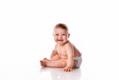 Bebek bezli şirin bebek beyaz arka planda mutlu gülümsüyor.