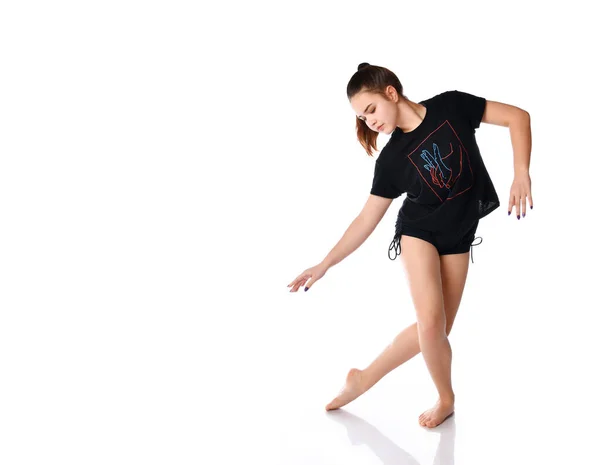 Flexible chica deportiva realiza elementos de baile sobre un fondo blanco en el estudio. — Foto de Stock