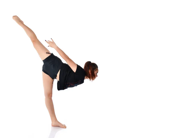 Ung flexibel flicka utför ett gymnastiskt element i studion på en vit bakgrund. — Stockfoto