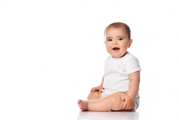 Adorável bebê sorrindo, sentado no chão, tiro de estúdio, isolado no fundo branco, lindo retrato do bebê — Fotografia de Stock