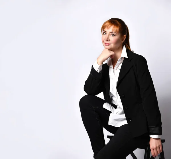 Junge Geschäftsfrau sitzt auf Stuhl gegen Wand — Stockfoto