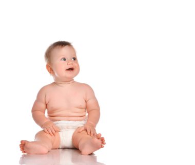 Çocuk bebek bebek oturuyor ve mutlu bir şekilde gülümsüyor beyaz bir arka plana bakıyor..