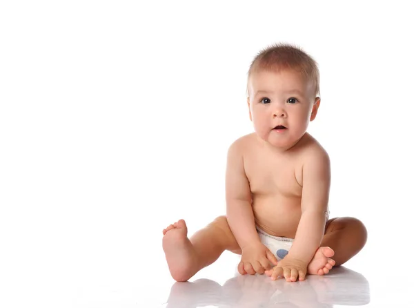 Little baby in nappy on floor stretching out by hand — Stock Photo, Image