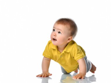 Beyaz zeminde sürünen meraklı bir bebek.