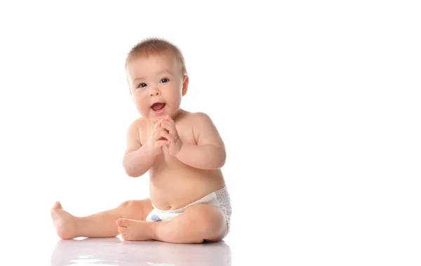 Leuke kleine baby in luier klappen hand op de vloer — Stockfoto