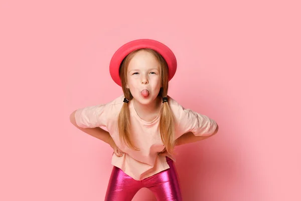 Menina travesso inclinado para a frente com as mãos sobre os quadris e lolling enquanto provocando ou trolling alguém. Close up tiro isolado em rosa — Fotografia de Stock